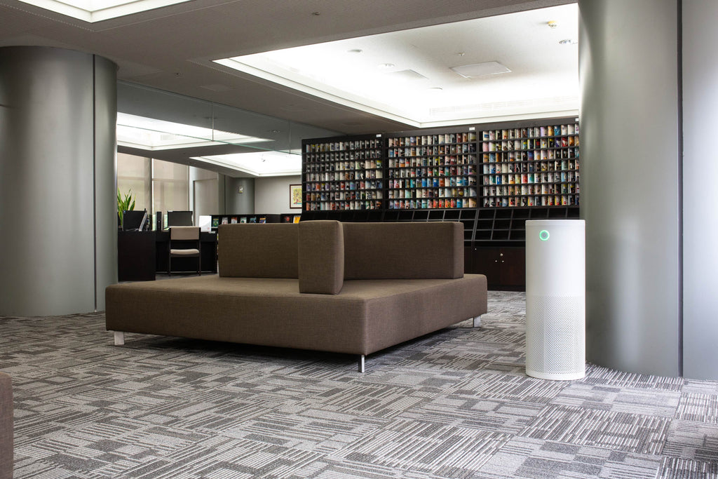 Ruime woonkamer met taupe kleur bankstel en witte AirExchange 600-T luchtreiniger