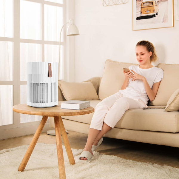 Dame in woonkamerr met AirExchange 150‑T, fluisterstille luchtreiniger, voor schone lucht en betere slaap, wit